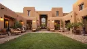 A luxurious house constructed from traditional mud brick, featuring a spacious central courtyard and a meticulously manicured lawn. The interior is adorned with exquisite antique luxury furniture, blending ru (1).webp